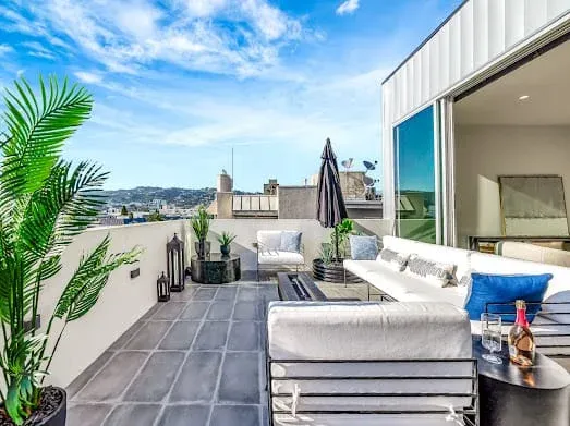 124 S Croft Ave — Exterior: Luxury rooftop terrace with white sectional seating and panoramic Los Angeles views
