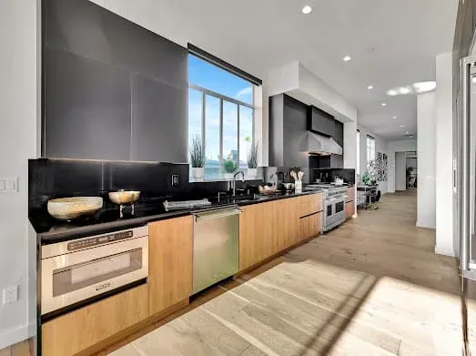 124 S Croft Ave — Kitchen: Luxury kitchen with wood grain cabinets and black countertops