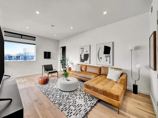 124 S Croft Ave — Living Areas: Sophisticated living room with tan leather sectional and contemporary art